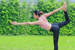Porträt asiatischer Frauen, die trainieren, indem sie Yoga im Garten praktizieren. Konzeptübung für Gesundheit und Entspannung. Frau macht glücklich Yoga im Park foto
