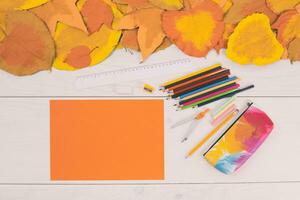 Herbst Blätter und Orange Papier und Schule liefert auf Weiß hölzern Hintergrund foto