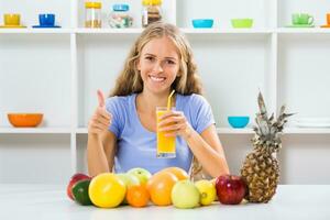 schön Mädchen genießt Trinken Orange Saft und zeigen Daumen oben beim ihr Zuhause foto