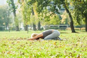 schön Frau ausüben Yoga draussen foto