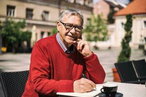 Senior Geschäftsmann genießt Arbeiten und Trinken Kaffee beim das Bar foto