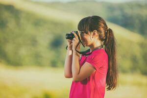 schön wenig Mädchen genießt im Natur mit Fernglas foto