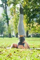 schön Frau ausüben Yoga draussen foto