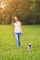 schön Frau genießt Gehen mit ihr süß Hund Jack Russell Terrier im das Natur foto