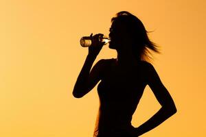 Silhouette von ein Frau Trinken Wasser draussen foto