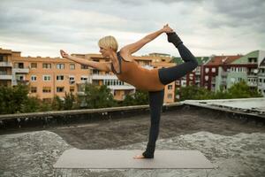 Frau üben Yoga auf das Dach foto