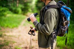 Bild von Mann Wandern und mit Fernglas foto