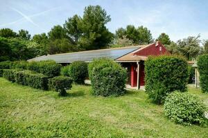 ein rot Haus mit Solar- Paneele auf das Dach foto