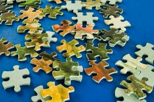 ein Stapel von Puzzle Stücke auf ein Blau Oberfläche foto