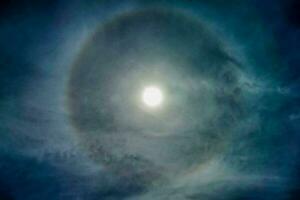 das Mond ist gesehen im das Himmel mit ein Heiligenschein um es foto