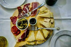 ein Teller von Käse, Fleisch und Oliven auf ein Tabelle foto