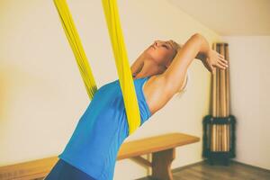 Frau tun Antenne Yoga im das Fitness Studio foto