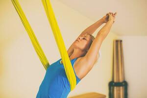 Frau tun Antenne Yoga im das Fitness Studio foto