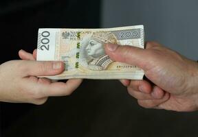 männlich Hand geben ein bündeln von groß Banknoten zu weiblich Hände. selektiv Fokus foto