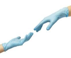 zwei Hände im steril Blau Nitril Handschuhe erreichen aus zu jeder andere. Haut Schutz während Epidemien und Quarantäne. Dort ist ein Platz zum Text foto