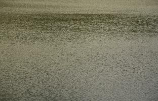 die Textur von dunklem Flusswasser unter Windeinfluss, perspektivisch eingeprägt. horizontales Bild foto