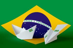 Brasilien Flagge abgebildet auf Papier Origami Flugzeug und Boot. handgemacht Kunst Konzept foto