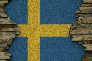 Schweden Flagge abgebildet im Farbe Farben auf alt Stein Mauer Nahaufnahme. texturiert Banner auf Felsen Mauer Hintergrund foto