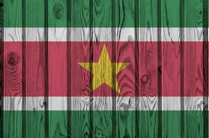 suriname Flagge abgebildet im hell Farbe Farben auf alt hölzern Mauer. texturiert Banner auf Rau Hintergrund foto