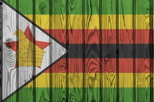 Zimbabwe Flagge abgebildet im hell Farbe Farben auf alt hölzern Mauer. texturiert Banner auf Rau Hintergrund foto