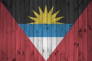 Antigua und Barbuda Flagge abgebildet im hell Farbe Farben auf alt hölzern Mauer. texturiert Banner auf Rau Hintergrund foto