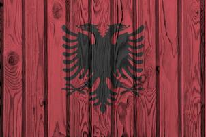 Albanien Flagge abgebildet im hell Farbe Farben auf alt hölzern Mauer. texturiert Banner auf Rau Hintergrund foto