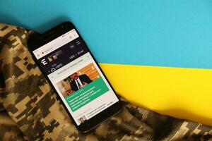 Kiew, Ukraine - - 4 dürfen, 2023 ukrainisch Nachrichten Portal auf Smartphone Bildschirm mit ukrainisch Flagge und tarnen Stoff foto