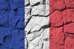 Frankreich Flagge abgebildet im Farbe Farben auf alt Stein Mauer Nahaufnahme. texturiert Banner auf Felsen Mauer Hintergrund foto