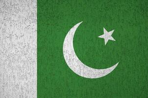 pakistan-flagge in hellen farben auf alter reliefputzwand dargestellt. strukturierte Fahne auf rauem Hintergrund foto