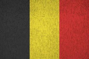 belgische flagge in hellen farben auf alter reliefputzwand dargestellt. strukturierte Fahne auf rauem Hintergrund foto