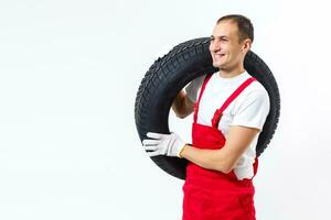 Porträt von lächelnd männlich Mechaniker halten Reifen auf Weiß Hintergrund foto