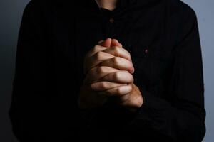 Bild von beten Hände auf ein schwarz Hintergrund foto
