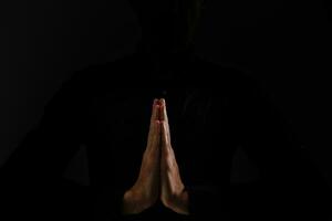 beten Hände auf ein schwarz Hintergrund foto