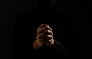 Bild von beten Hände auf ein schwarz Hintergrund foto