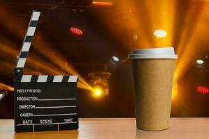 Film Klöppel und Tasse von Kaffee auf hölzern Bretter Hintergrund foto
