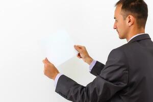 Geschäftsmann halten ein leer Weiß Planke, Schild, zeigen ein leer Rechnung Tafel gegen Weiß Hintergrund foto
