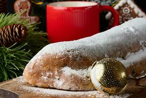 Weihnachten Gebäck Stollen bestreut mit pulverisiert Zucker auf das Tisch, festlich Dessert foto