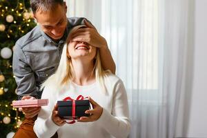 Porträt von glücklich Paar umarmen, suchen Nieder beim Geschenk im Frau Hand foto