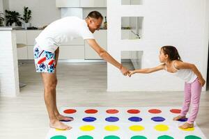 glücklich Familie haben Spaß zusammen, spielen Twister Spiel beim Zuhause foto