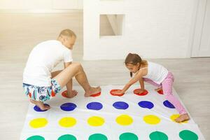wenig Mädchen und Vater abspielen Twister beim Zuhause foto