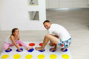 Tochter und Vater abspielen Twister beim Zuhause foto