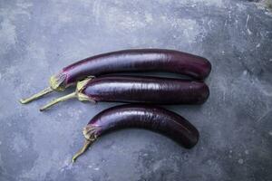 frisch Aubergine auf ein schwarz Beton Fußboden foto