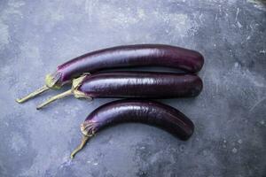 frisch Aubergine auf ein schwarz Beton Fußboden foto