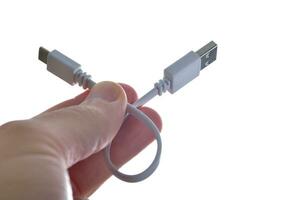 Makro Fotografie von Weiß USB-C Kabel im das Hand isoliert auf Weiß Hintergrund foto