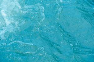 Blau Wasser mit Wellen auf das Oberfläche. defokussieren verschwommen transparent weiß schwarz farbig klar Ruhe Wasser Oberfläche Textur mit Spritzen und Blasen. Wasser Wellen mit leuchtenden Muster Textur Hintergrund. foto