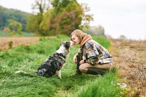 draussen Porträt von schön jung Frau spielen mit australisch Schäfer Hund foto