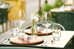 draussen Restaurant Terrasse mit serviert Tisch, klein gemütlich Vase mit Weiß Blumen foto