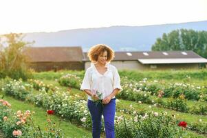 Landschaft Lebensstil, draussen Porträt von schön Mitte Alter 50 - - 55 Jahr alt Frau genießen nett Tag im Blume Bauernhof Garten foto