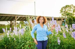 draussen Porträt von schön 50 Jahr alt Frau genießen nett Tag im Blume Park oder Garten, glücklich und gesund Lebensstil foto