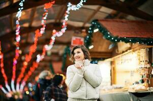 draussen Porträt von glücklich jung Frau beim Weihnachten Markt foto